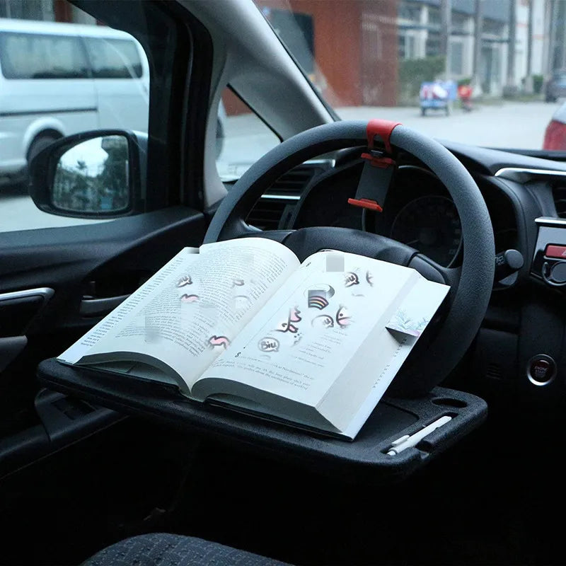 Une tablette de voiture installée sur le volant, idéale pour la lecture, avec un livre ouvert pour maximiser l’ergonomie et le confort du conducteur.