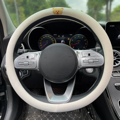Couvre-volant Dryyver Vibe™ avec broderie ourson discret sur fond crème – design mignon et créatif pour volant de voiture.