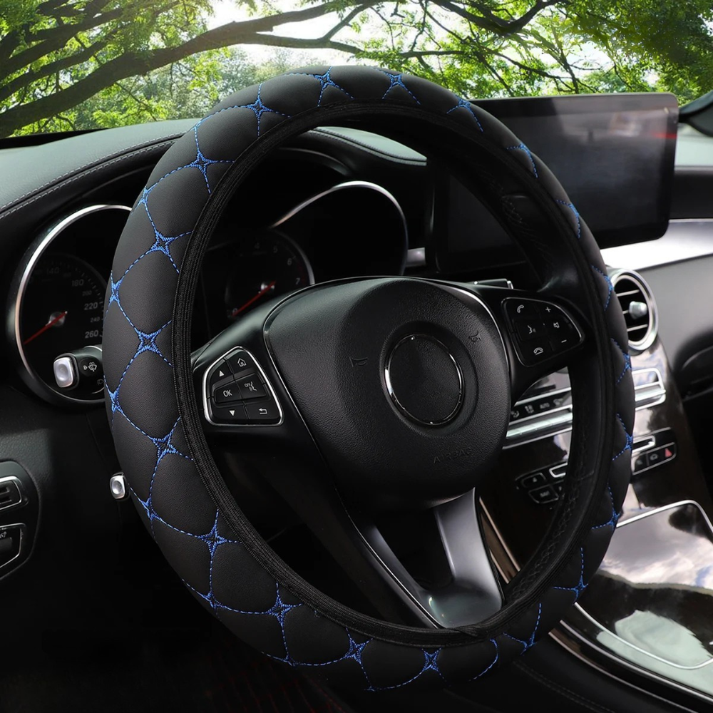 Couvre-volant Dryyver Zen noir avec surpiqûres bleues installé sur un volant, style matelassé ultra-confort.