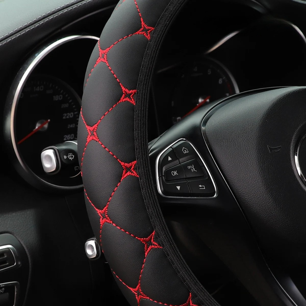 Gros plan sur le couvre-volant Dryyver Zen avec coutures rouges matelassées, offrant un confort supérieur et un style sportif.