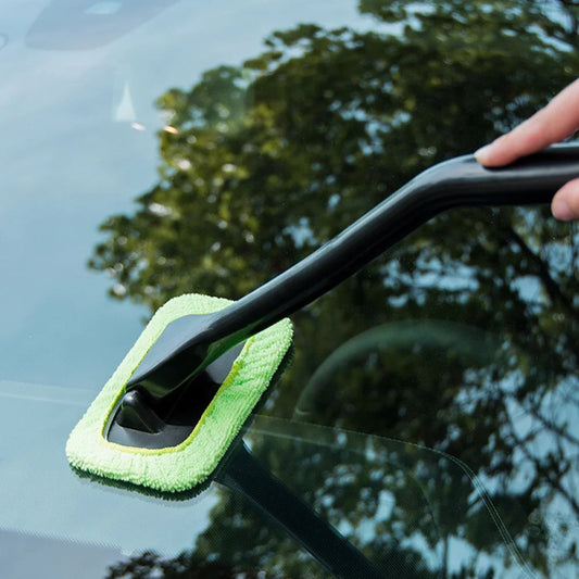 Tampon microfibre en action nettoyant un pare-brise de voiture pour une visibilité parfaite